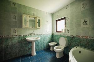 a bathroom with two toilets and a sink and a tub at Dea Apartments - Peja in Peje +49 photos