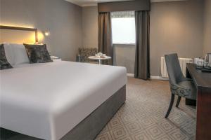 a hotel room with a large bed and a desk at Best Western Appleby Park Hotel in Tamworth