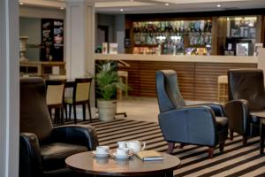 a lobby with chairs and a table and a bar at Best Western Appleby Park Hotel in Tamworth