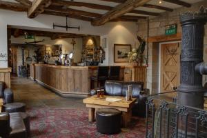 Eine Kneipe mit einer Bar, einem Tisch und Stühlen in der Unterkunft Beamish Hall Hotel, BW Premier Collection in Stanley