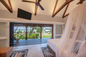 a bedroom with a bed and a balcony at Paradise Sun Hotel Seychelles in Baie Sainte Anne