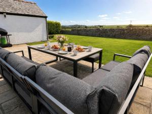 a table and chairs on a patio with a table at Bryniau in Pwllheli