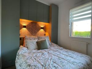 a bedroom with a bed with pillows and a window at L échappée bêle in Le Val-Saint-Père