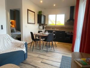a room with a table and chairs and a kitchen at L échappée bêle in Le Val-Saint-Père