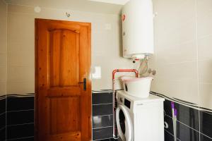a kitchen with a washing machine and a door at Dea Apartments - Peja in Peje