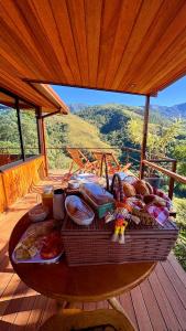 a table with a basket of food on a deck at Pousada Varandas da Mantiqueira in São Francisco Xavier +26 photos