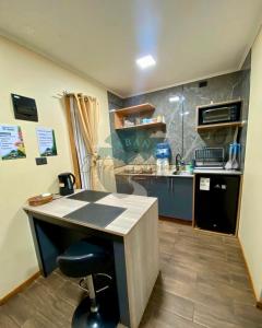 a kitchen with a counter and a desk in a room at Cabaña entre Bosques in Concepción