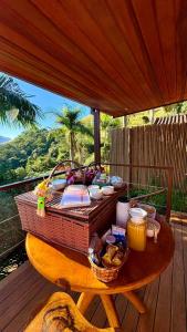 a picnic table with a basket of food on a deck at Pousada Varandas da Mantiqueira in São Francisco Xavier