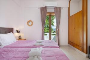 a bedroom with a large bed with a purple blanket at Dionysus House in Magoulás