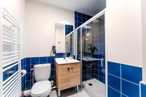 a blue tiled bathroom with a toilet and a sink at Studio for 2 in La Teste-de-Buch parking in La Teste-de-Buch