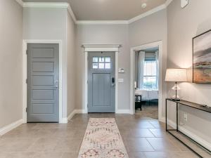a hallway with a blue door and a rug at Exquisite Escape in Moore! in Moore