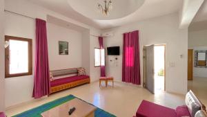 a living room with pink curtains and a couch at Villa Sunset résidence Djerba in Djerba