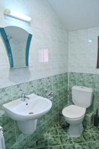 ein Badezimmer mit weißer Toilette und Waschbecken in der Unterkunft Кирицова Къща in Bansko + 49 Fotos