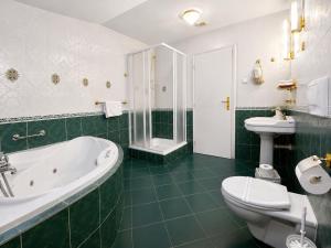 a bathroom with a tub and a toilet and a sink at Park Hotel Tartuf in Beladice