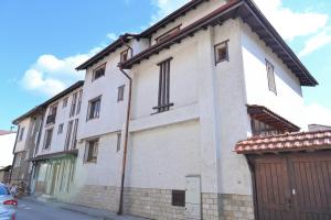 ein großes weißes Gebäude an einer Straße in der Unterkunft Кирицова Къща in Bansko