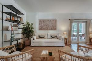 a living room with a white couch and chairs at Casa das Cegonhas in Vale de guiso +75 photos