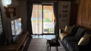 a living room with a couch and a tv at Ghxabara Cozy Cabin in Maun