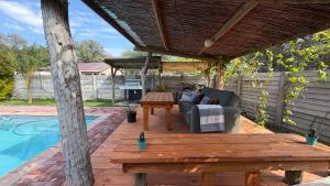 a patio with a couch and a table next to a pool at Ghxabara Cozy Cabin in Maun