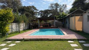 a small swimming pool in a yard with a shed at Ghxabara Cozy Cabin in Maun