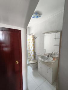 a white bathroom with a toilet and a sink at Casa Airiños do monte in Cangas de Morrazo +20 photos