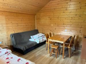 a room with a couch and a table in a room at POD FALAMI - domki letniskowe in Polańczyk