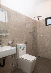 a bathroom with a toilet and a sink and a shower at Port Royal Residence in Trincomalee +30 photos