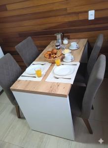 a table with chairs and a bowl of food on it at Chalé Vale Carahá Hortensia in Gramado +18 photos