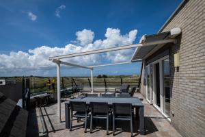 a patio with a table and chairs on a balcony at Penthouse Ostrea 60 in Nes