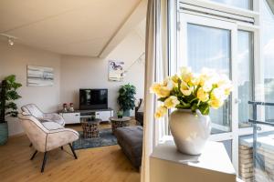 a living room with a vase of flowers on a table at Penthouse Ostrea 60 in Nes