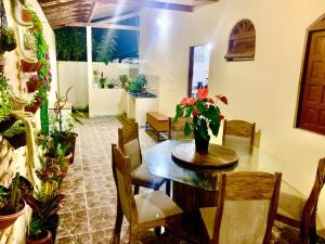 a dining room with a table and chairs and potted plants at Casa para a temporada com 3 quartos a caminho do centro in Porto Seguro