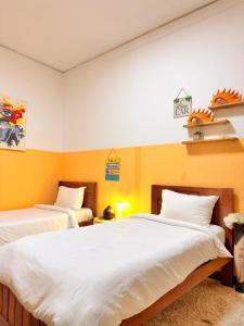 two beds in a room with yellow walls at Cozy & Secure 1BR Apartment in Central Luanda in Luanda