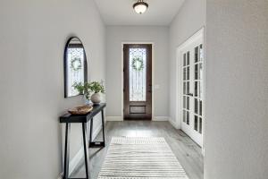 a hallway with a table and a mirror and a door at Hazy Hollow Escape 4816 in Crowley