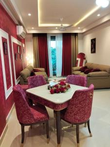 a living room with a table and chairs and a couch at LMY Boutique Prestige Hotel Apartments - Murree Monal Expressway in Murree +25 photos