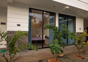 a house with glass doors with a bedroom in it at Port Royal Residence in Trincomalee