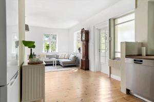 a kitchen and living room with white walls and wooden floors at 20335-Samso-Marsk-Stigs-vej-4 in Tranebjerg