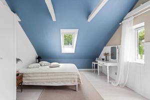 a bedroom with blue walls and a bed and a television at 20335-Samso-Marsk-Stigs-vej-4 in Tranebjerg