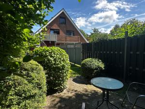 a backyard with a table and a fence and a house at Zaunkönigs Nest in Böhl