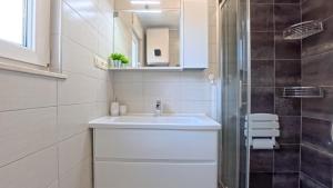 a white bathroom with a sink and a mirror at CASA di NATALIA, Spacious 2BR Apartment for 6 near Beach ,Free Parking in Kaštela +37 photos