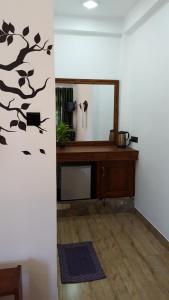 Zimmer mit einem Spiegel und einem Holzschreibtisch in der Unterkunft Lavendra Paradise in Ella