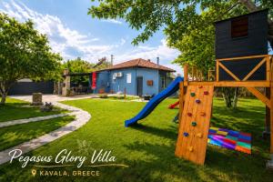 a playground with a slide in a yard at Pegasus Pool Villas Kavala in Kavála