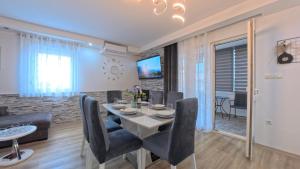 a dining room and living room with a table and chairs at CASA di NATALIA, Spacious 2BR Apartment for 6 near Beach ,Free Parking in Kaštela