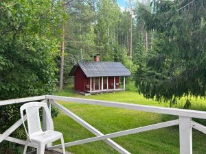 a chair on a porch with a small cabin at Villa Metsätähti Punkaharjulla in Vuoriniemi