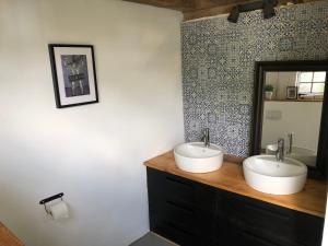 a bathroom with two sinks and a mirror at Bauwagen im Apfelgarten in Winsen