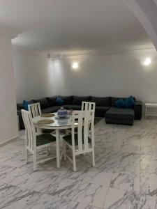 a living room with a table and chairs and a couch at Villa Syrine Djerba in Al Ḩaddādah