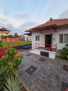 a house with a pool in front of it at Benny's Abode by UrbanEase Properties in Mangalore