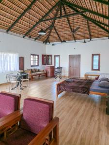 a large room with a bed and a table and chairs at Benny's Abode by UrbanEase Properties in Mangalore
