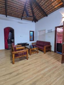 a living room with couches and a table at Benny's Abode by UrbanEase Properties in Mangalore