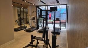 a gym with several tread machines in a room at U House in São Paulo