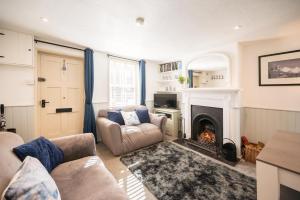 a living room with a couch and a fireplace at Fishermans Cottage, Aldeburgh in Aldeburgh