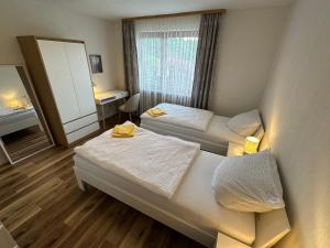 a hotel room with two beds and a window at Pension Katharina im Solling in Holzminden